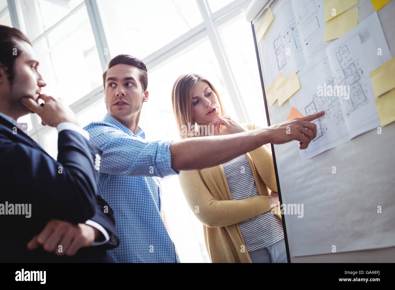 Imprenditore spiegando il blueprint ai colleghi di lavoro Foto Stock