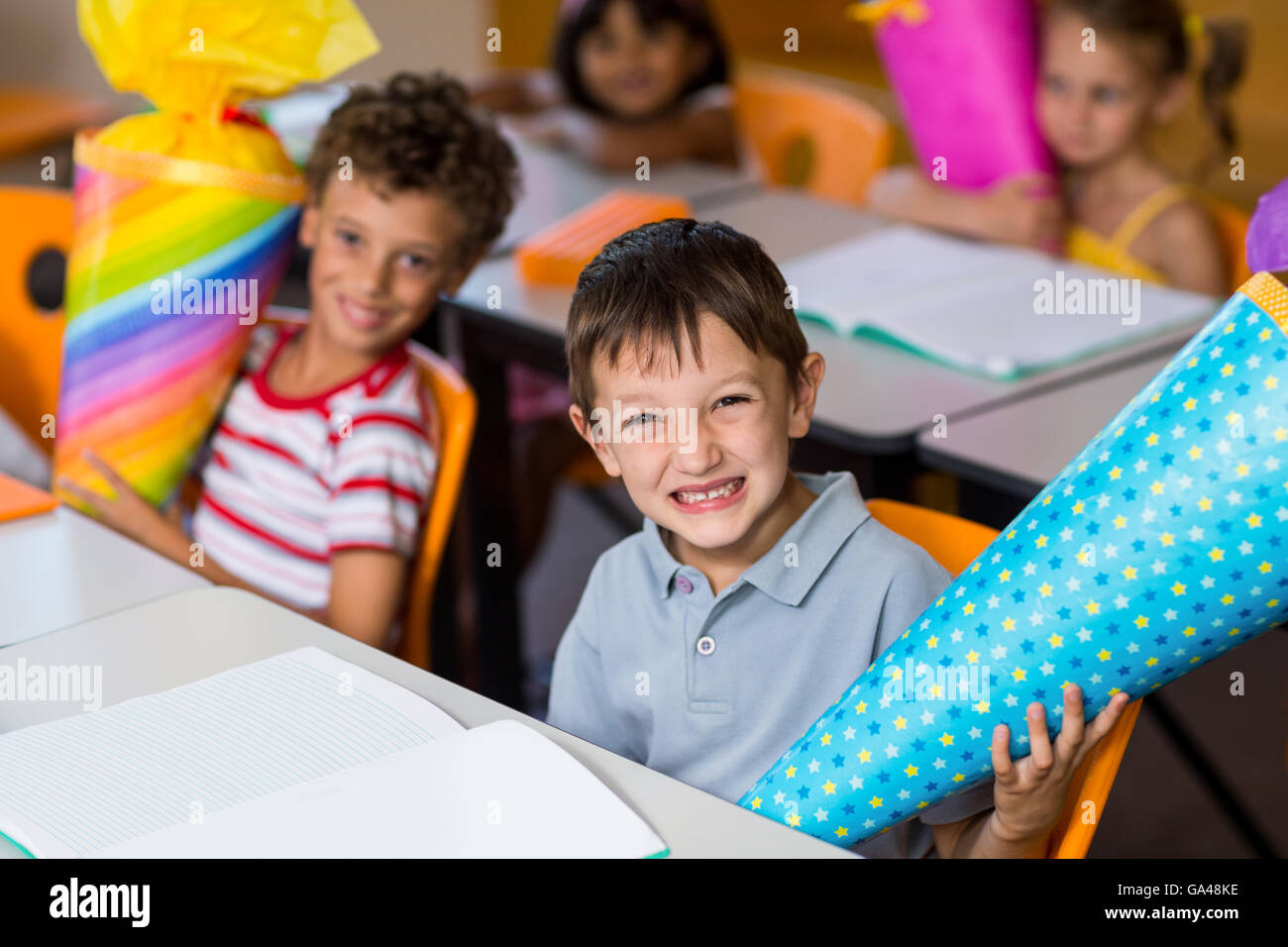 Allegro ragazzo con i compagni di classe di contenimento oggetto di artigianato Foto Stock