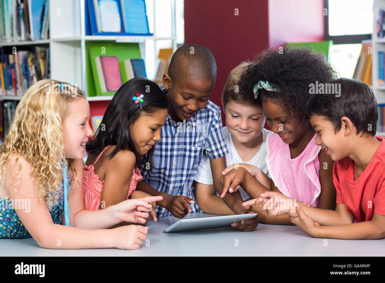 I bambini utilizzando il tavolo digitale in libreria Foto Stock