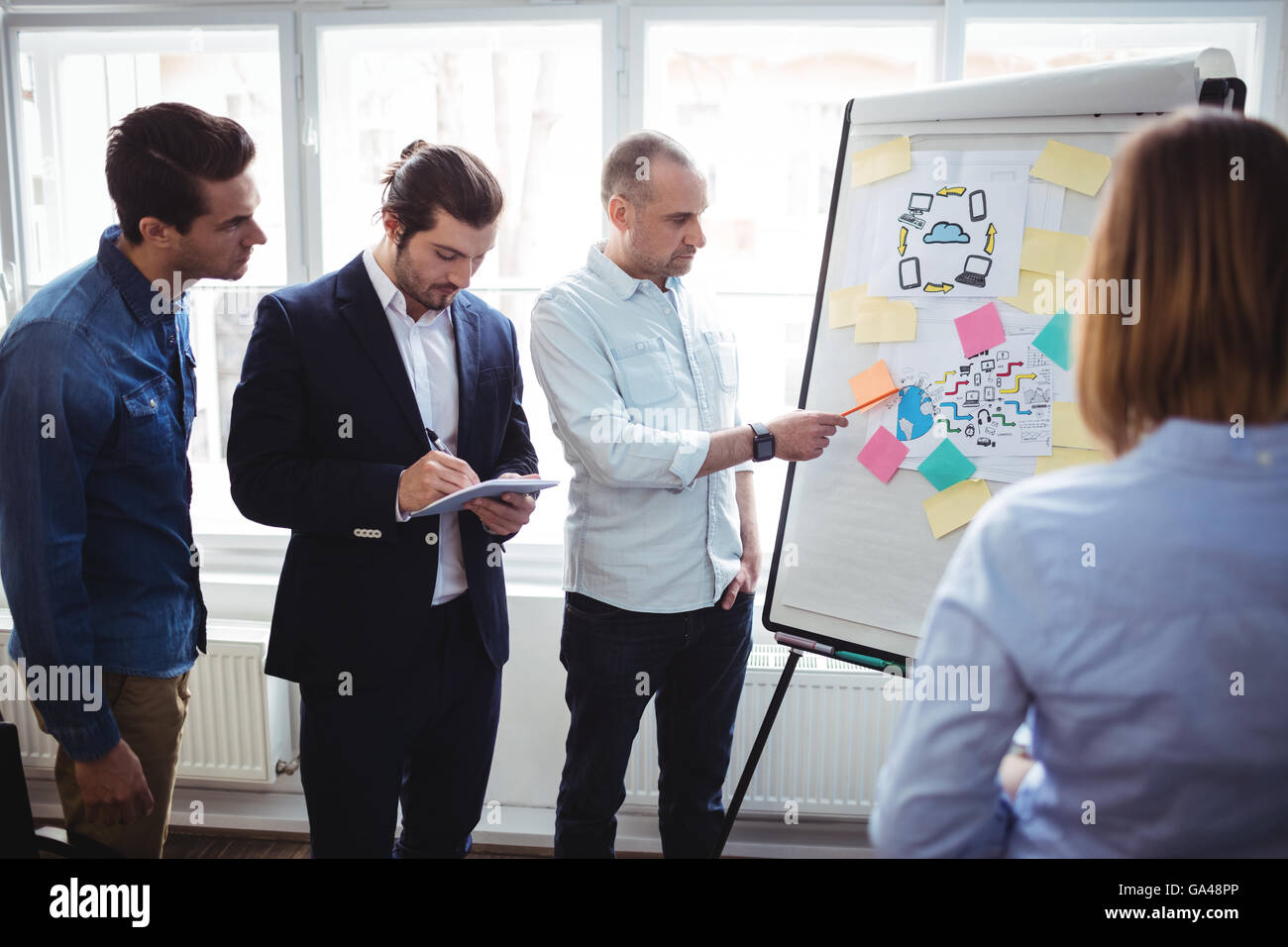 Imprenditore con i colleghi per discutere in sala riunioni Foto Stock