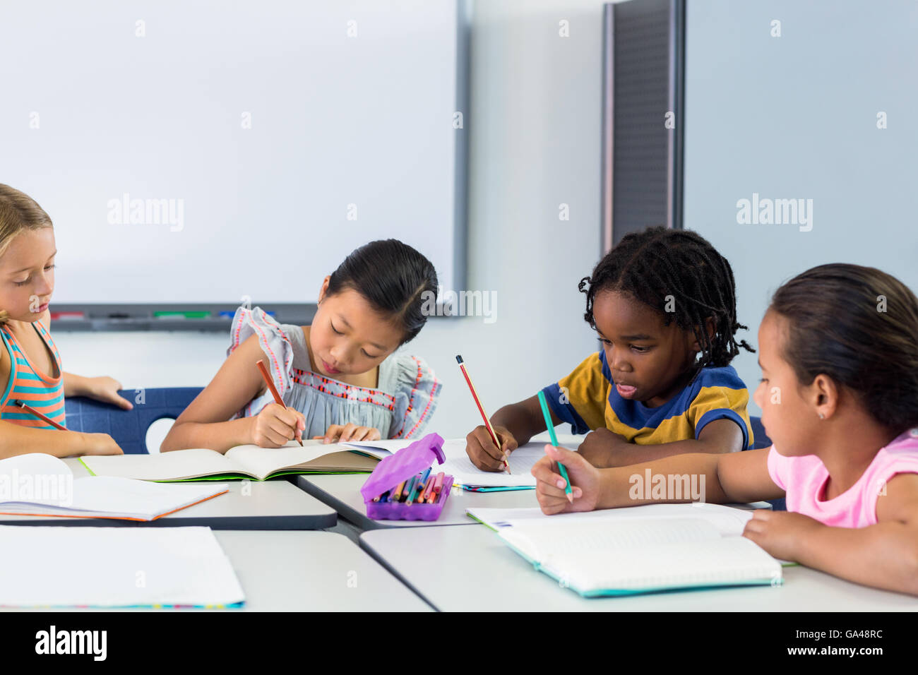 Scolari la scrittura sui libri Foto Stock