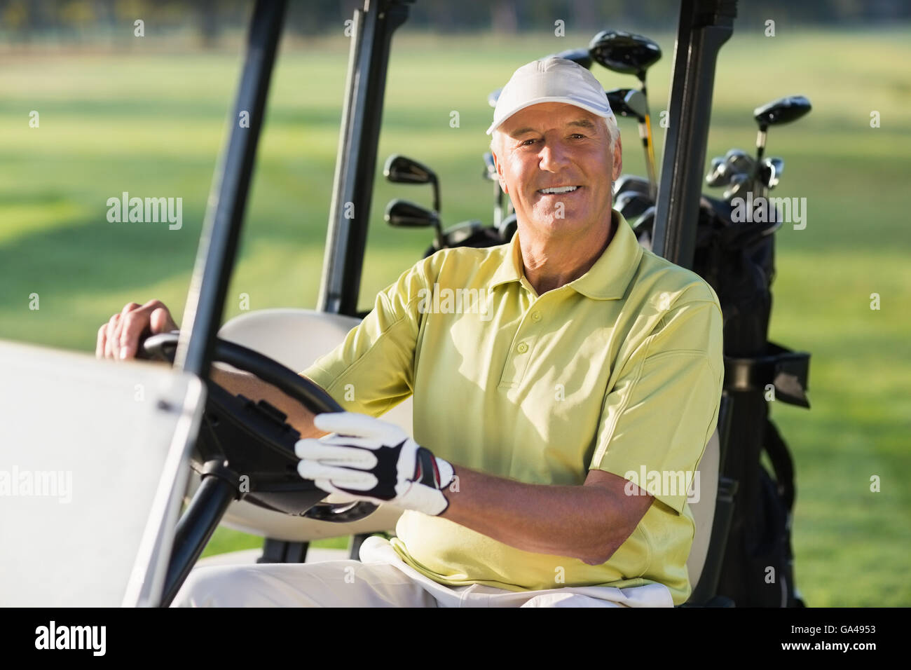 Ritratto di sorridere uomo maturo la guida golf buggy Foto Stock