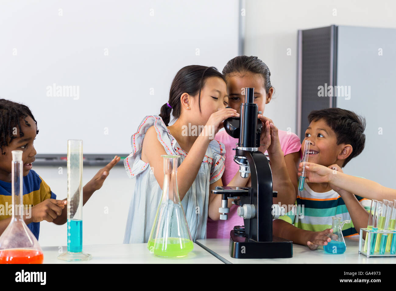 I bambini che cercano di microscopio Foto Stock
