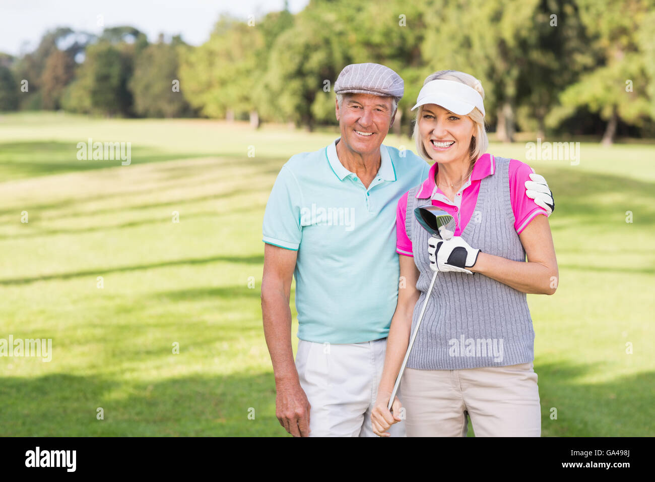 Sorridente Coppia matura permanente al campo da golf Foto Stock