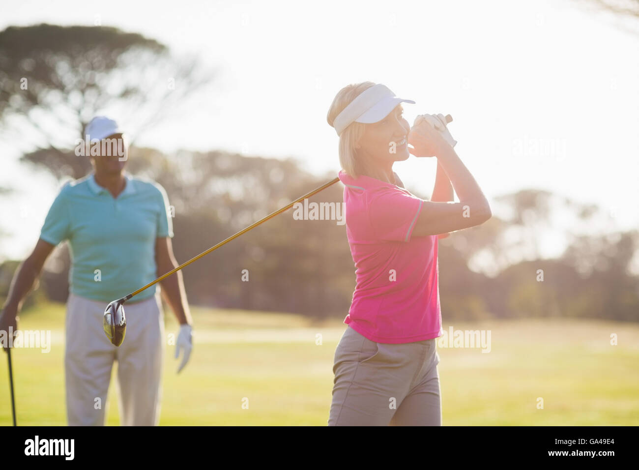 Sorridente coppia golfista giocando da uomo Foto Stock