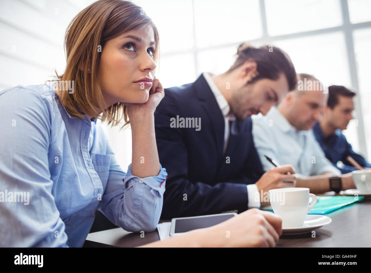 Imprenditrice premuroso con i colleghi in sala riunioni Foto Stock