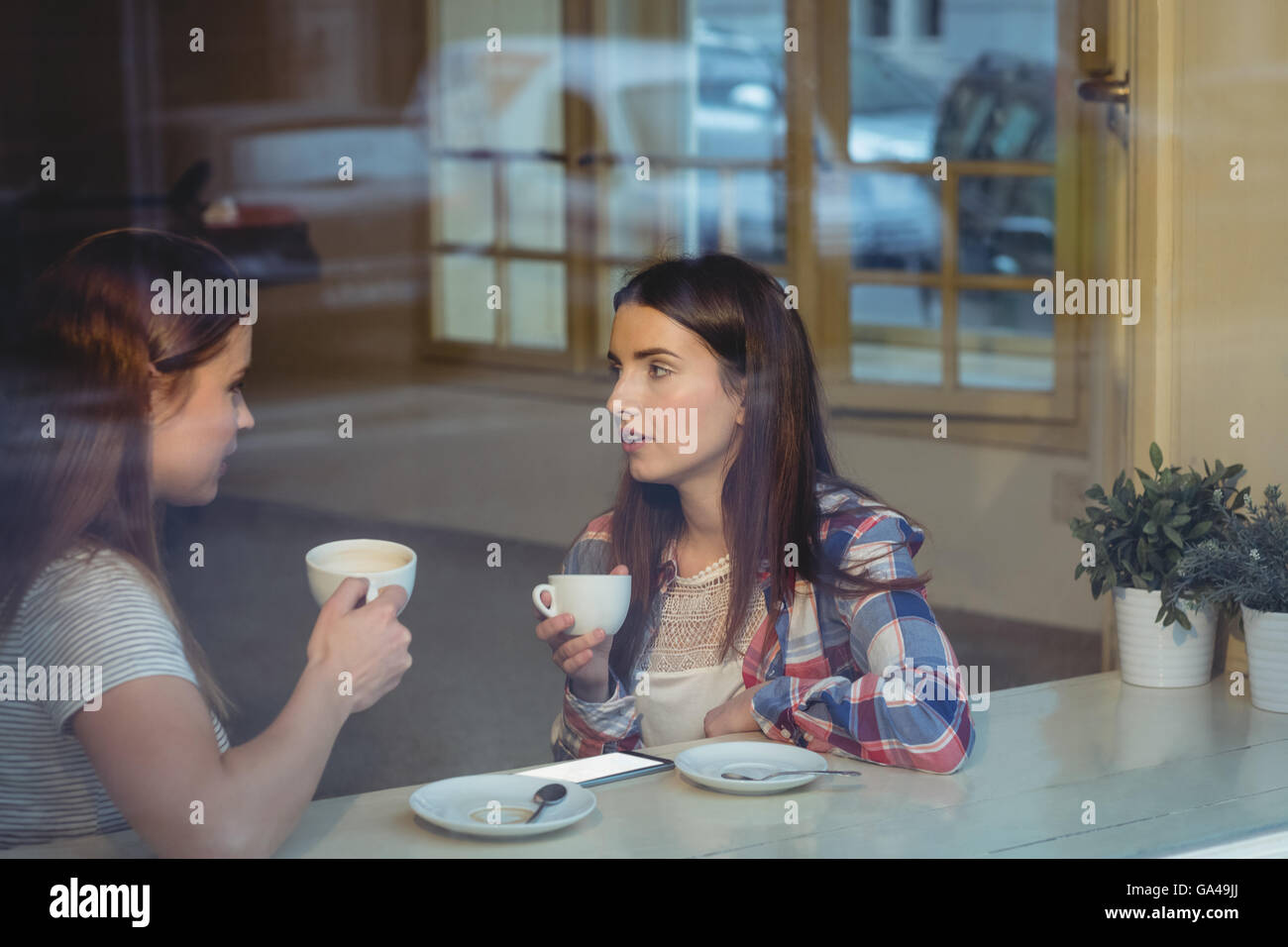 Giovani amici comunicando al cafe Foto Stock