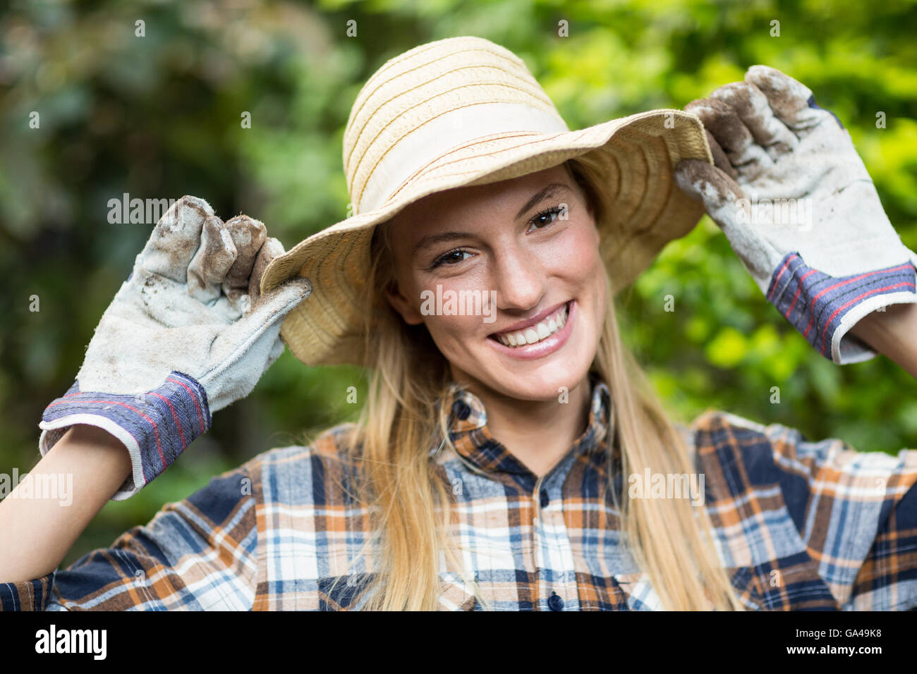 Felice giardiniere femmina indossando hat Foto Stock