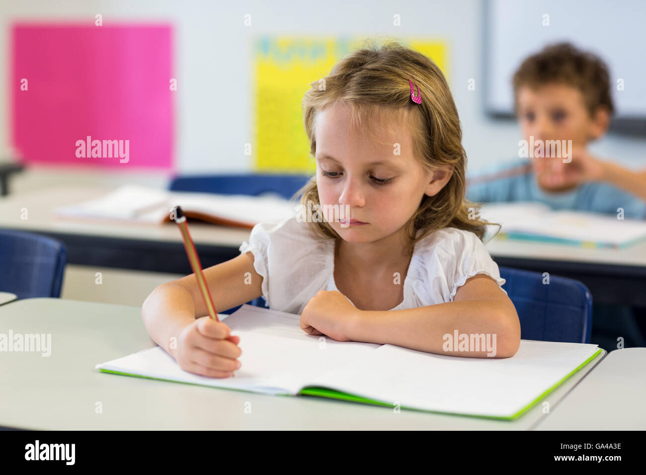 Ragazza seria la scrittura sul libro Foto Stock