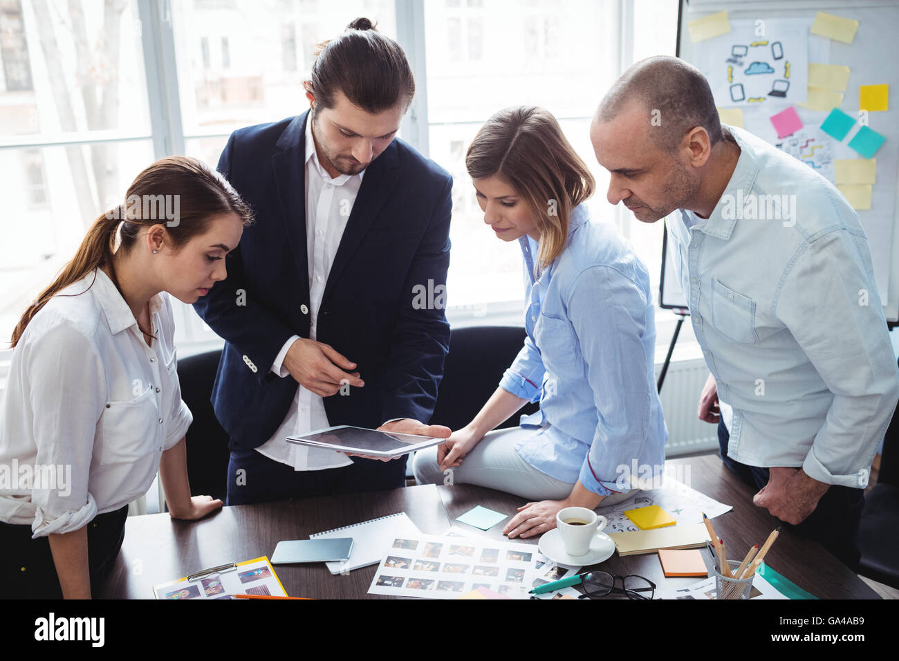 Editor foto utilizzando tavoletta digitale nella sala riunioni Foto Stock