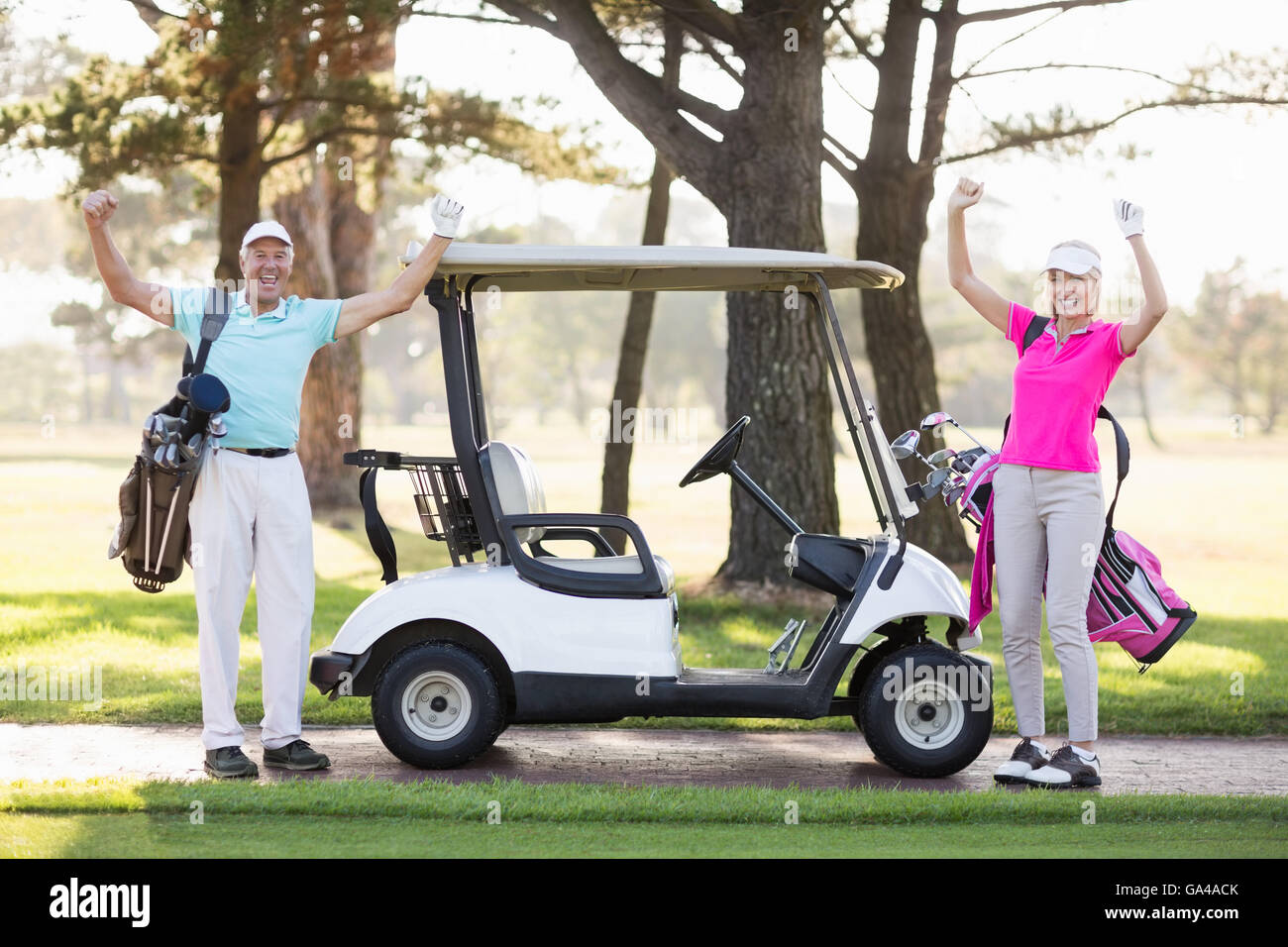 Ritratto di sorridente golfista maturo giovane con le braccia sollevate Foto Stock