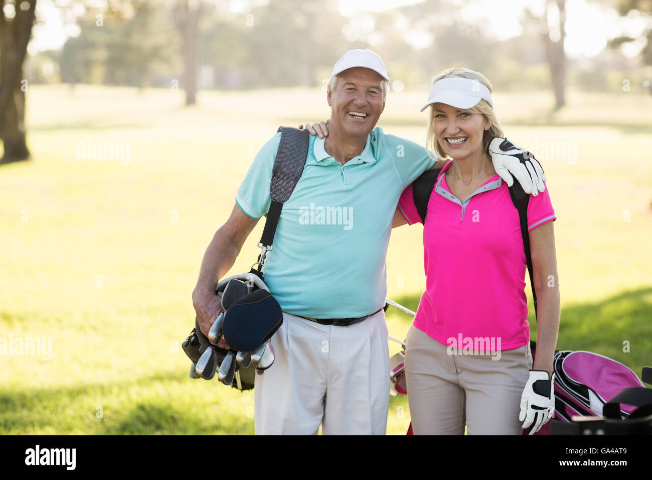 Felice coppia golfista giovane con braccio intorno a Foto Stock
