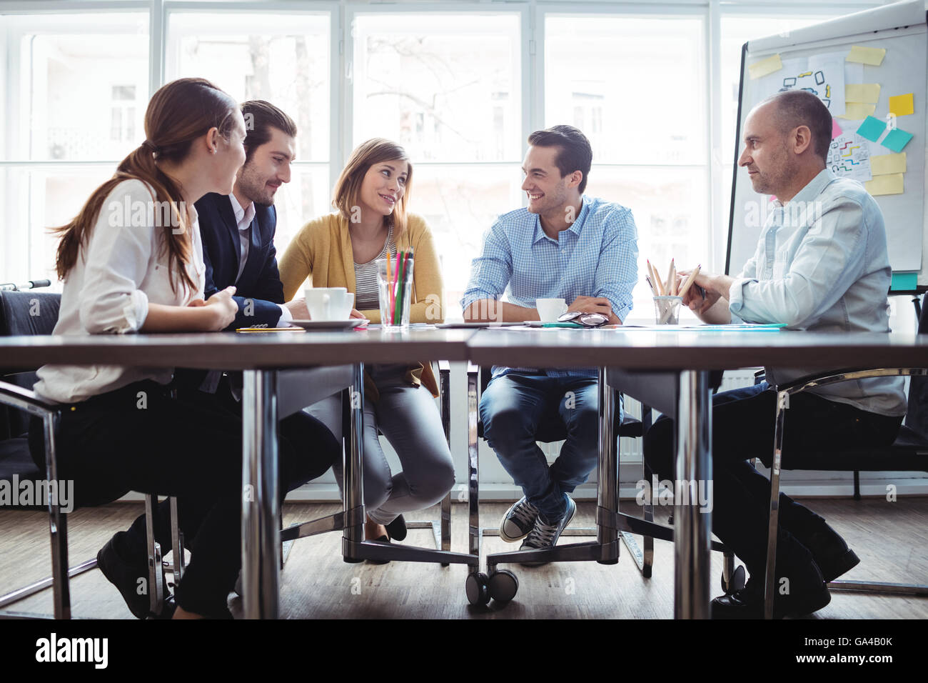 I colleghi discutendo in sala riunioni Foto Stock