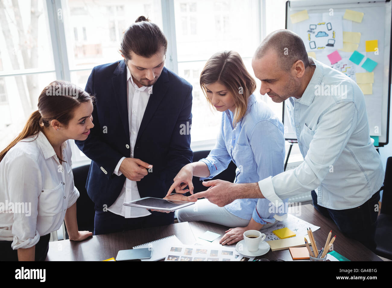 I redattori con tavoletta digitale nella sala riunioni Foto Stock