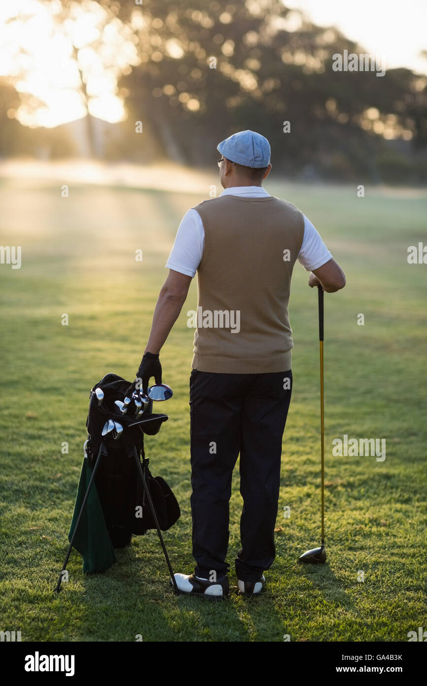 Vista posteriore dell'uomo in piedi al campo da golf Foto Stock