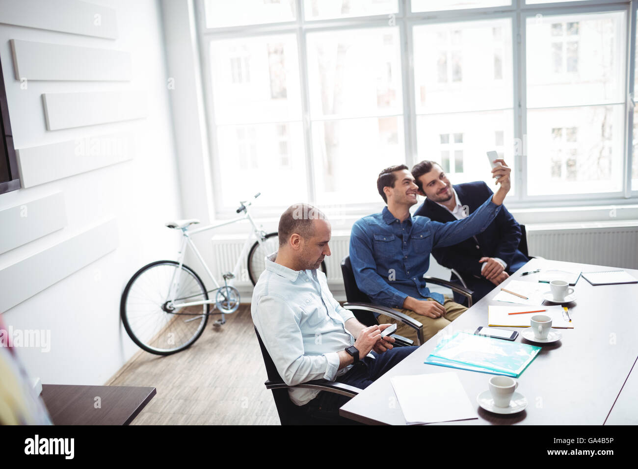 La gente di affari tenendo selfie in sala riunioni Foto Stock