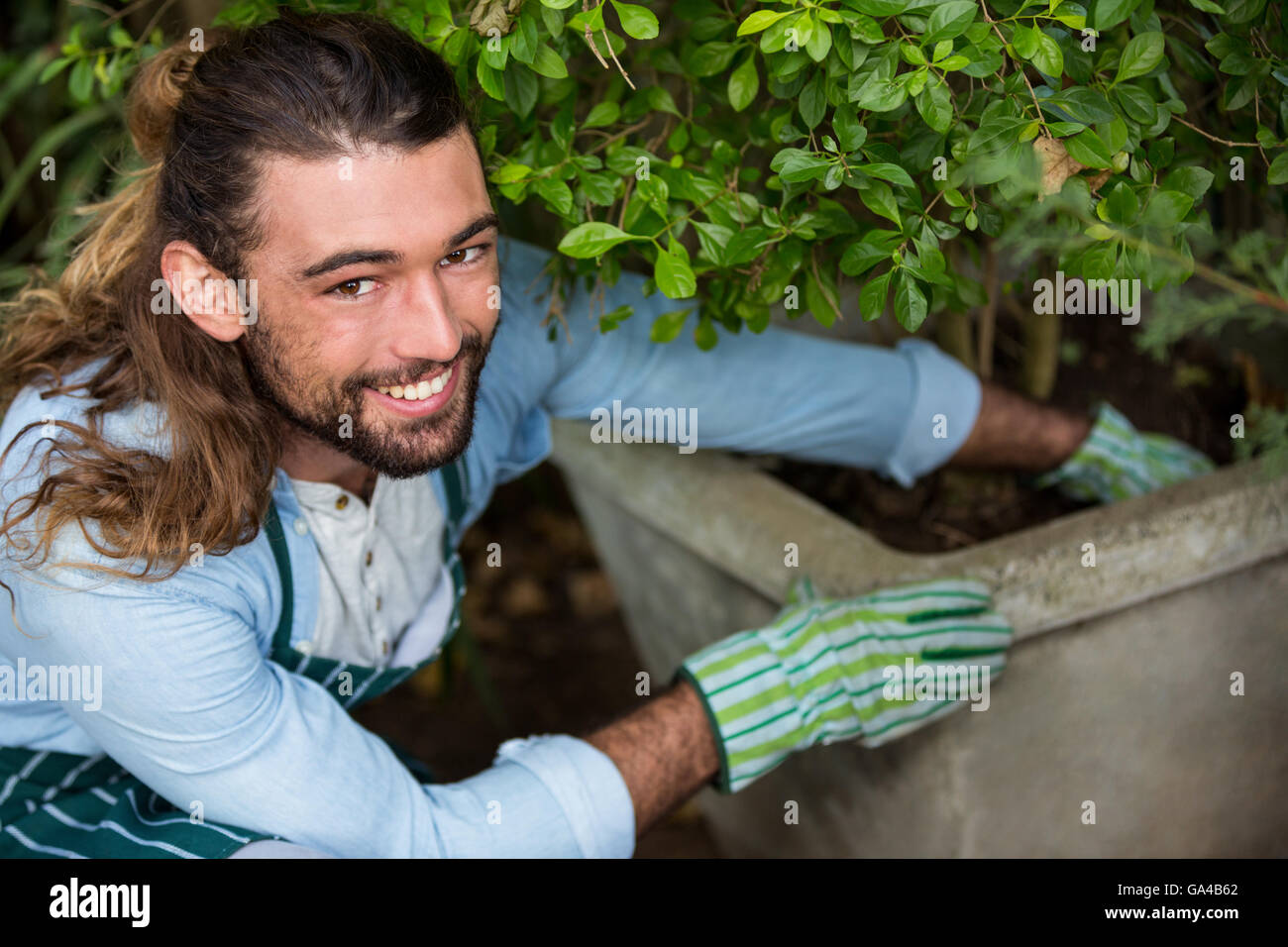 Ritratto di felice piantando dei lavoratori a livello comunitario che a livello giardino Foto Stock