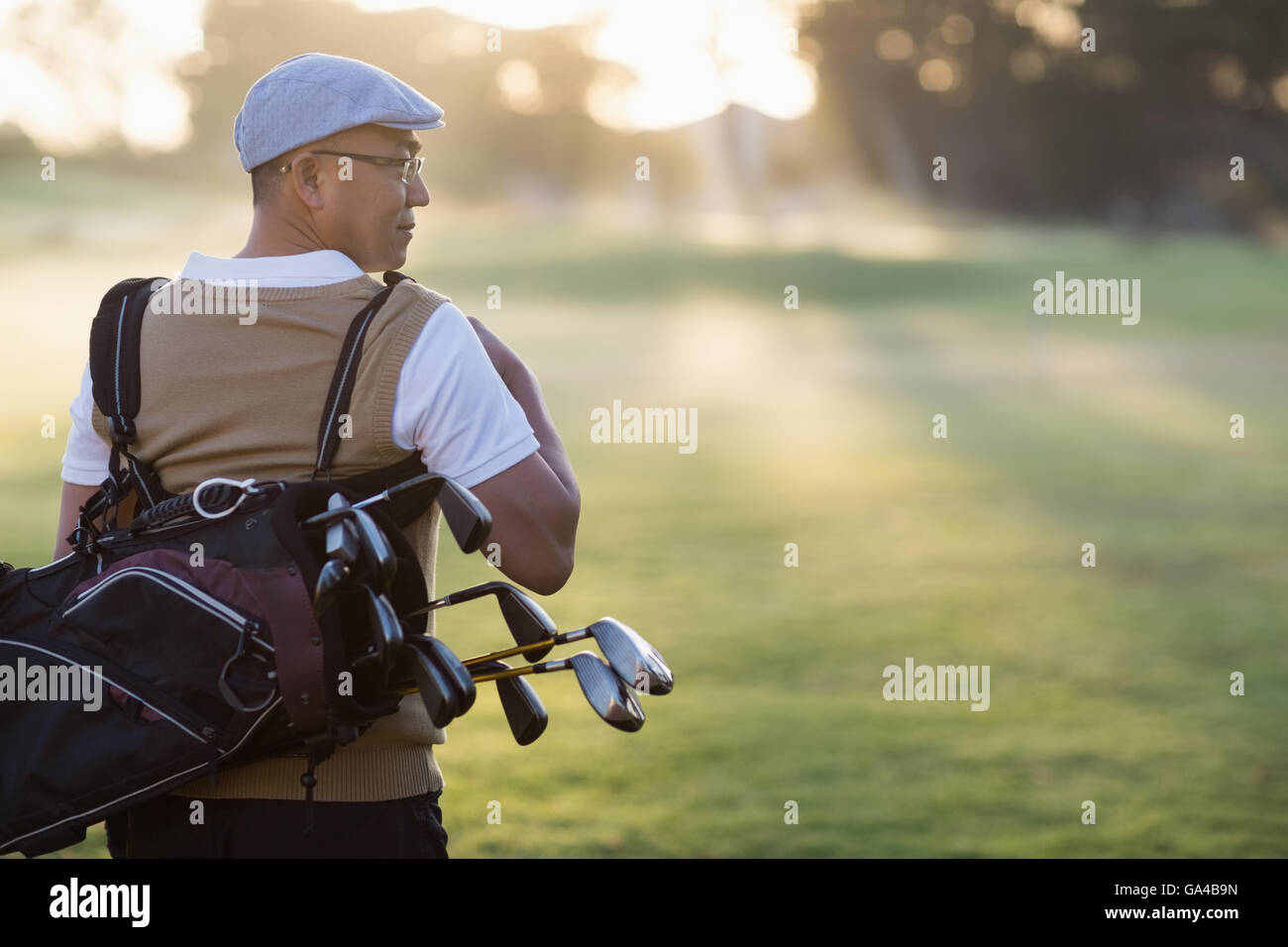 Vista posteriore di uomo maturo che trasportano borsa da golf Foto Stock