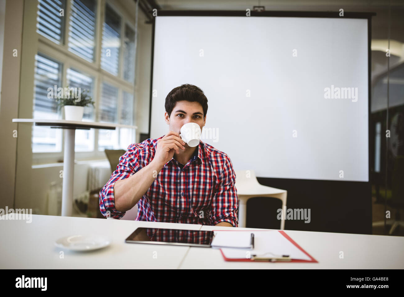Imprenditore avente caffè nella sala riunioni Foto Stock