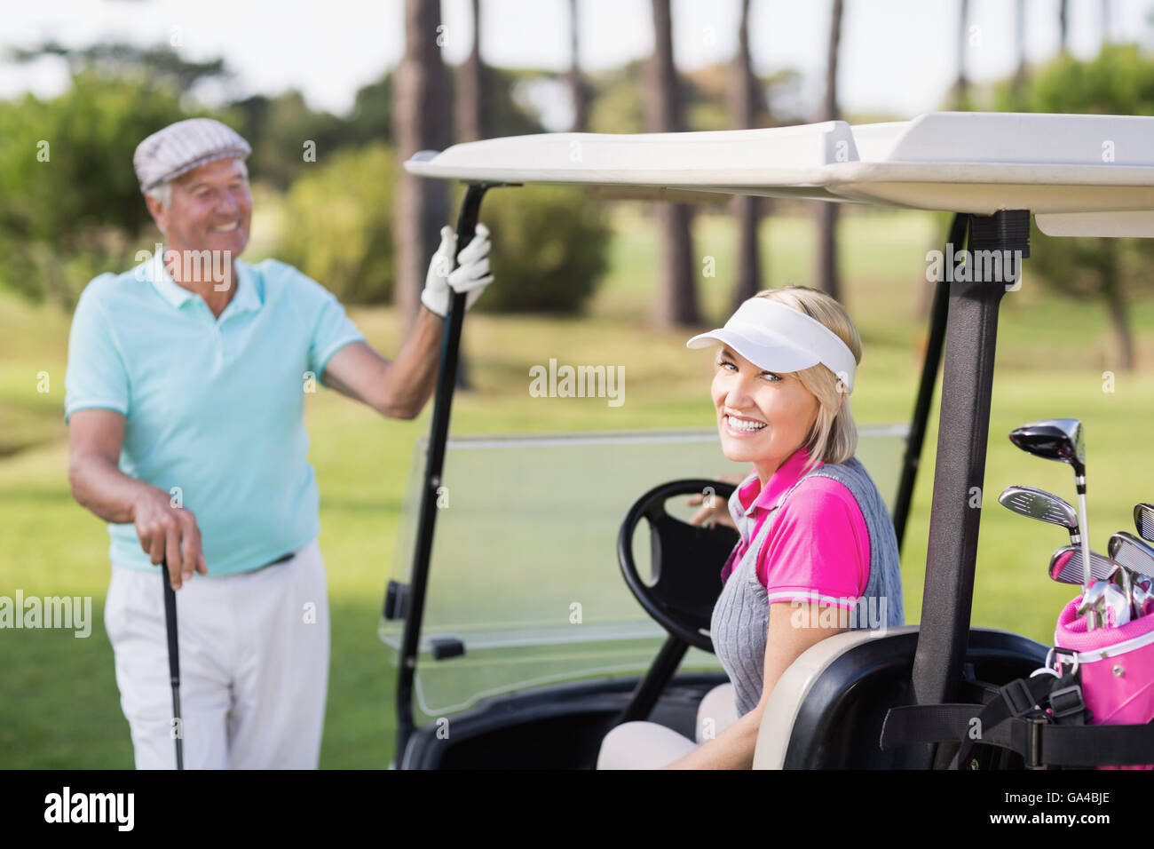Sorridente donna matura in seduta golf buggy Foto Stock