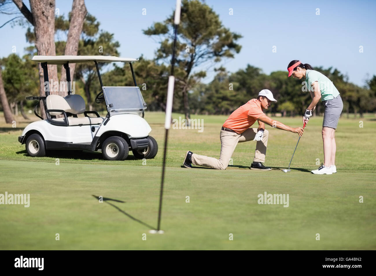 Uomo Donna insegnamento giocando a golf Foto Stock