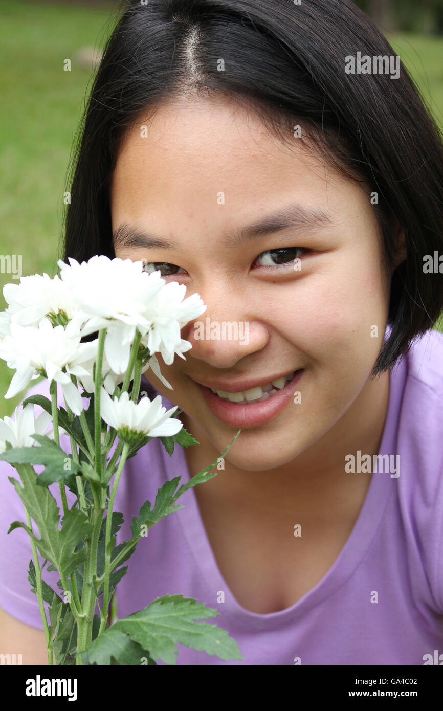 Ritratto di carino ragazza asiatica tenendo i fiori, il tempo primaverile. Foto Stock
