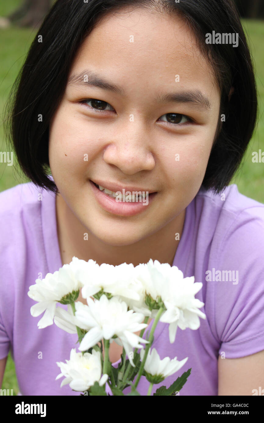 Ritratto di carino ragazza asiatica tenendo i fiori, il tempo primaverile. Foto Stock