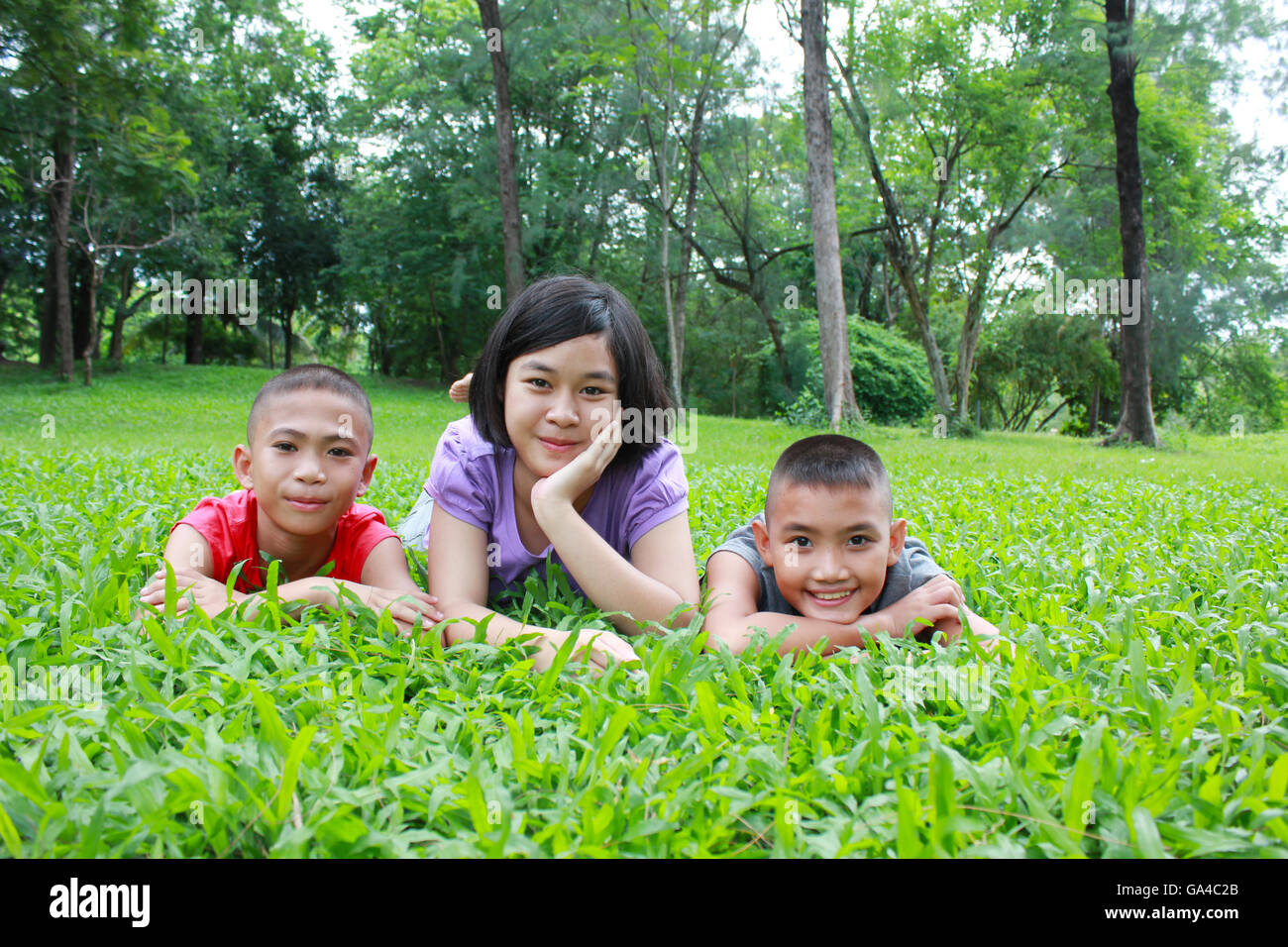 Tre ragazzi asiatici avente un buon tempo nel parco, il tempo primaverile. Foto Stock