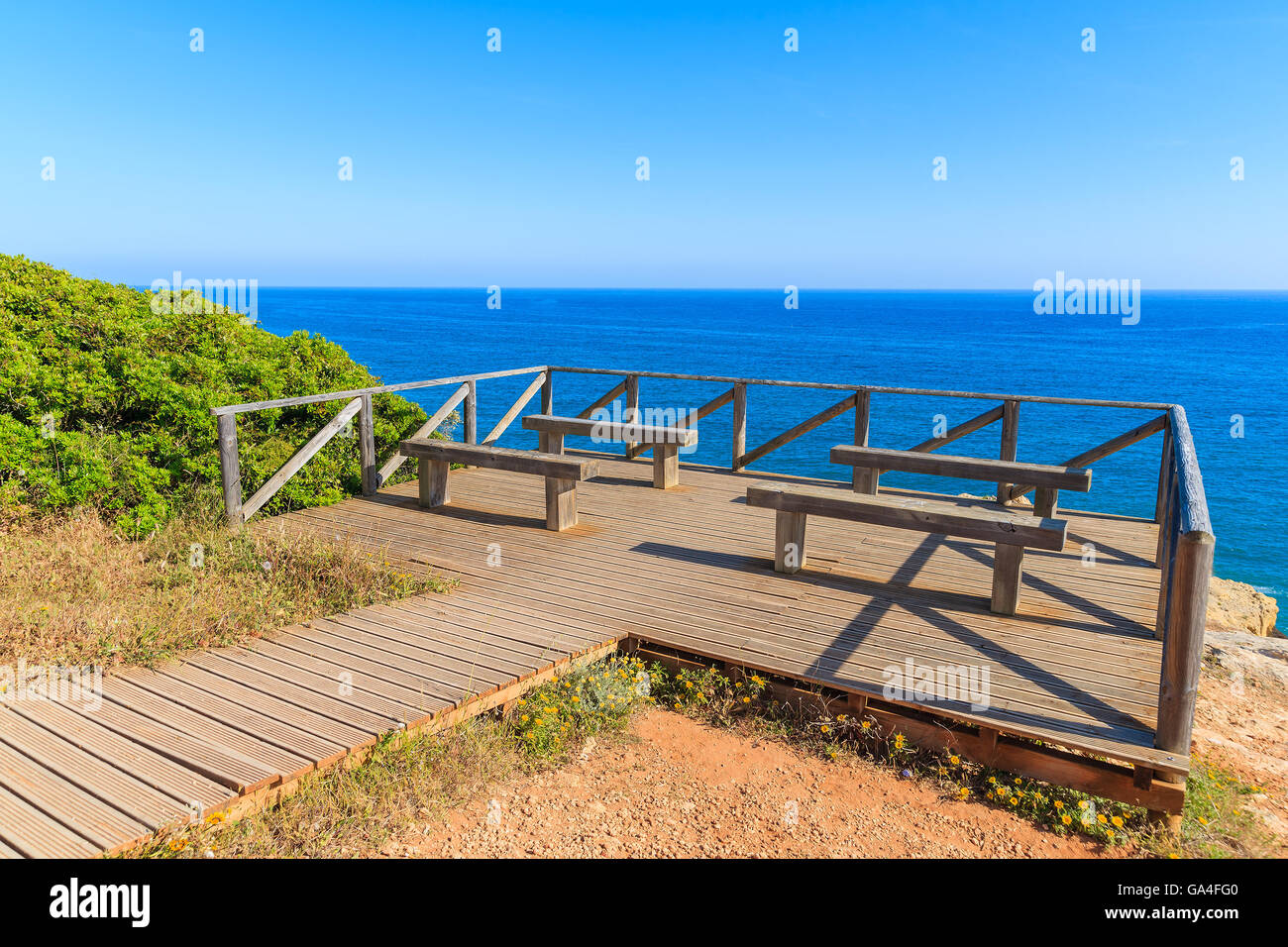 Ponte di legno con panchine per i turisti sulle coste del Portogallo in Carvoeiro città, regione Algarve Foto Stock