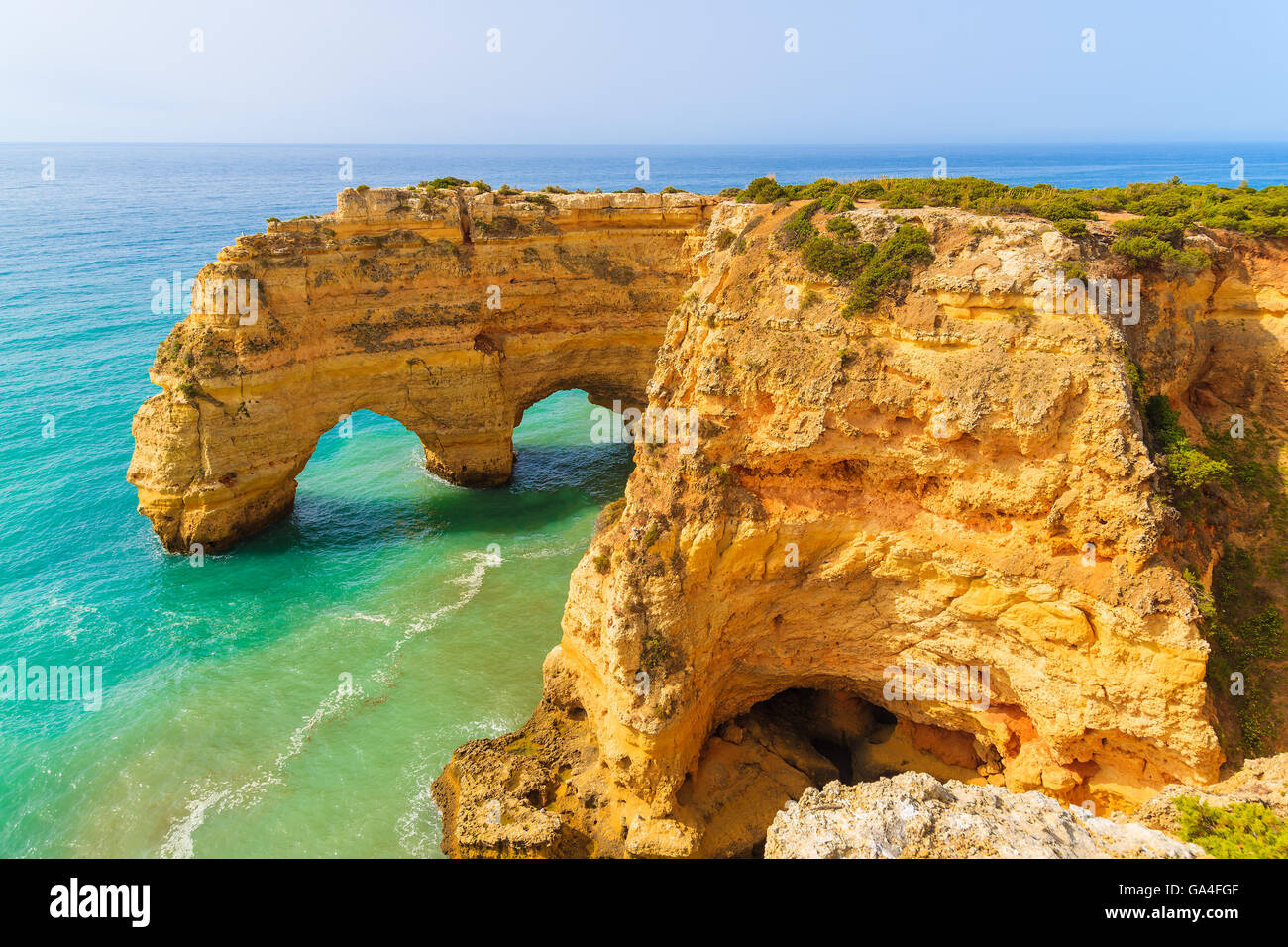 Roccia archi su Marinha spiaggia e mare turchese dell'acqua sulla costa del Portogallo nella regione di Algarve Foto Stock