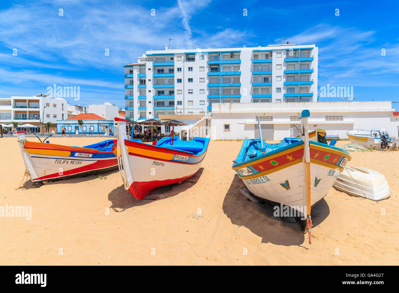 ARMACAO DE PERA Beach, Portogallo - 17 Maggio 2015: tipiche barche di pescatori sulla spiaggia di Armacao de Pera città costiera con appartamento edificio in background. Regione di Algarve è meta di vacanze. Foto Stock