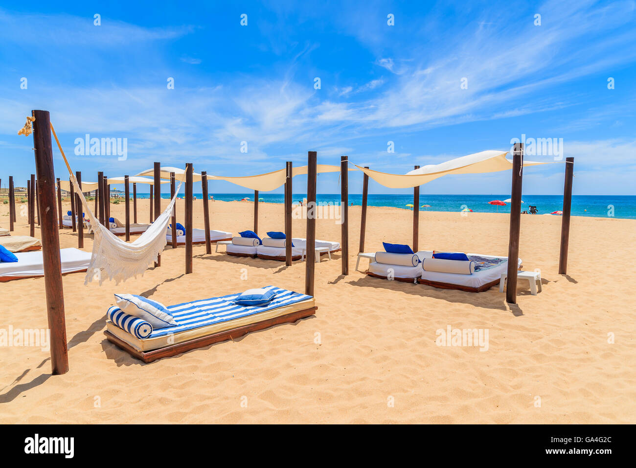 I lettini sulla spiaggia sabbiosa di salpe cittadina balneare, regione Alrgarve, Portogallo Foto Stock