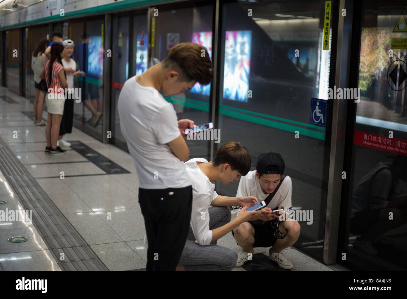 I giovani cinesi giocare con i loro smartphone e social media, a Pechino, Cina Foto Stock