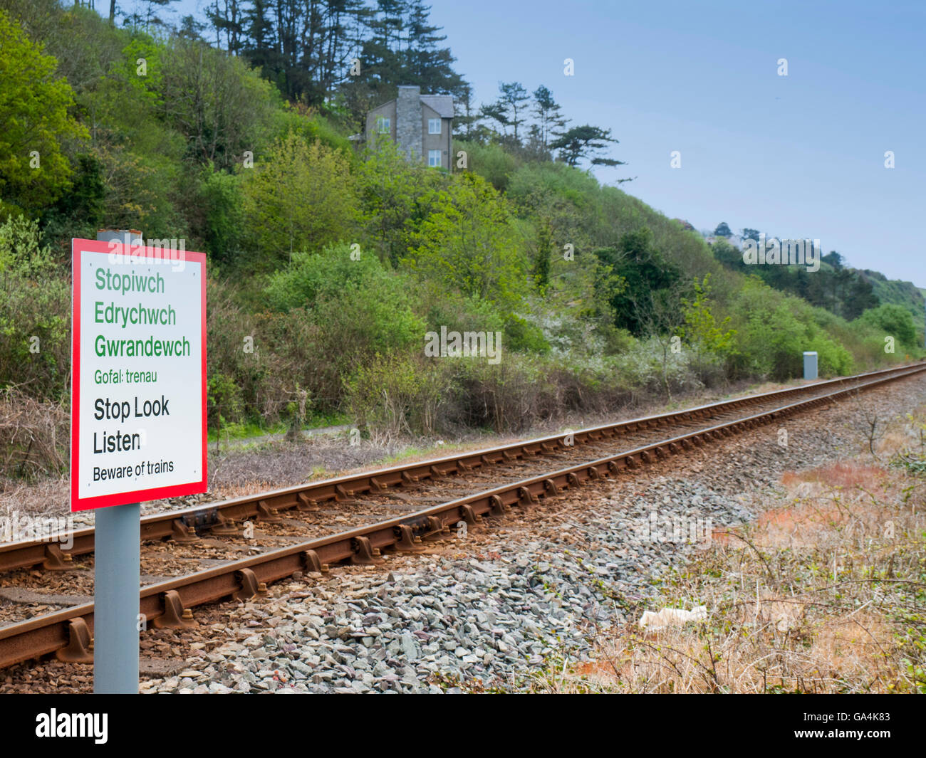 Smettere di guardare ascoltare incrocio ferroviario cartello di avviso in lingua inglese e gallese Foto Stock