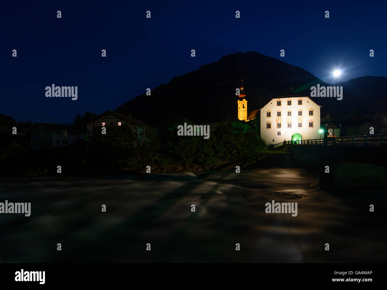 Pfunds chiesa Santi Pietro e Paolo , la Locanda ponte sopra il fiume Inn e la casa a torre con la luna piena Austria Tirol, Tirolo Ob Foto Stock