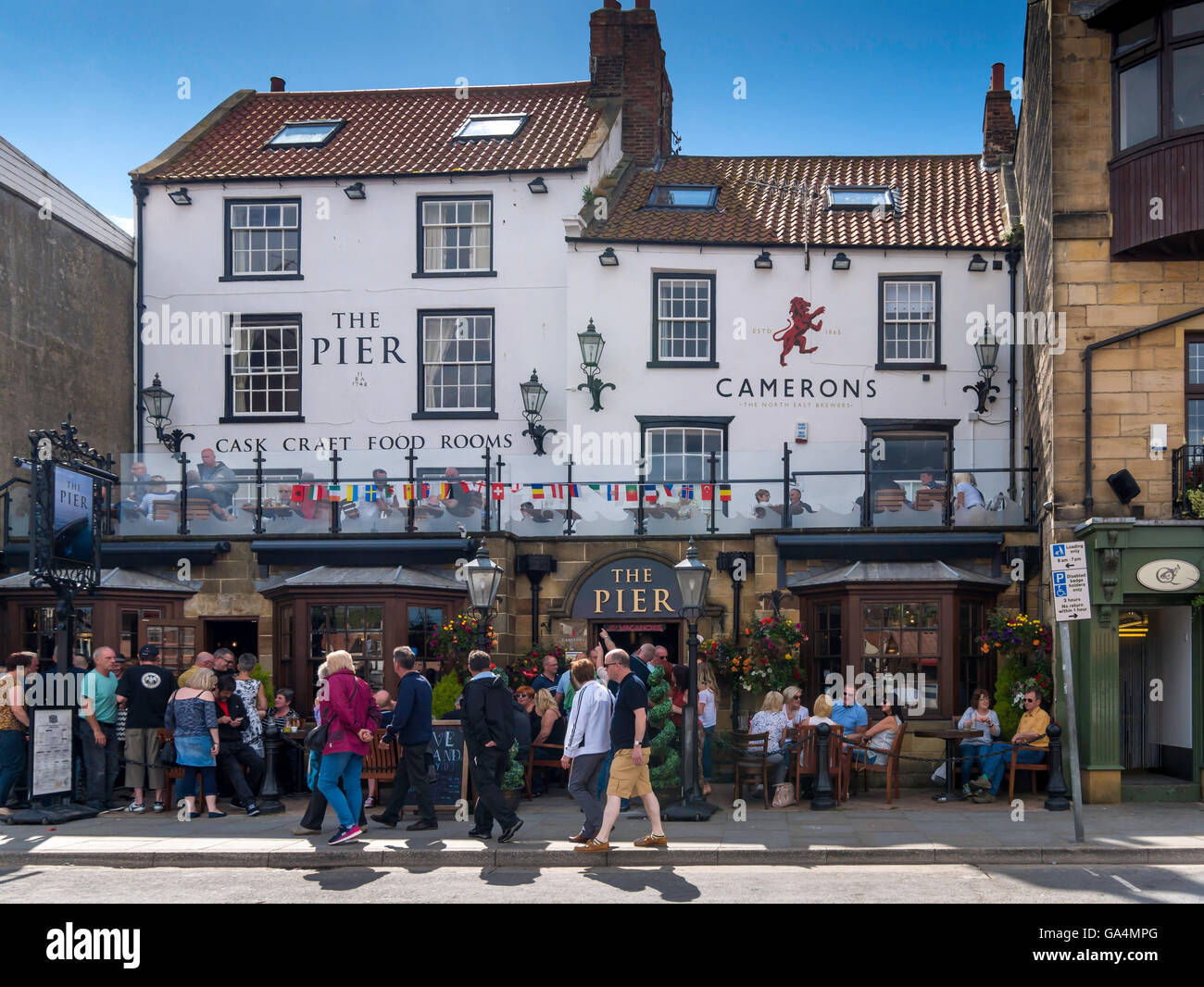 Il Molo Pub vicino al porto di Whitby Regno Unito Inghilterra molto occupato in un pomeriggio di estate Foto Stock