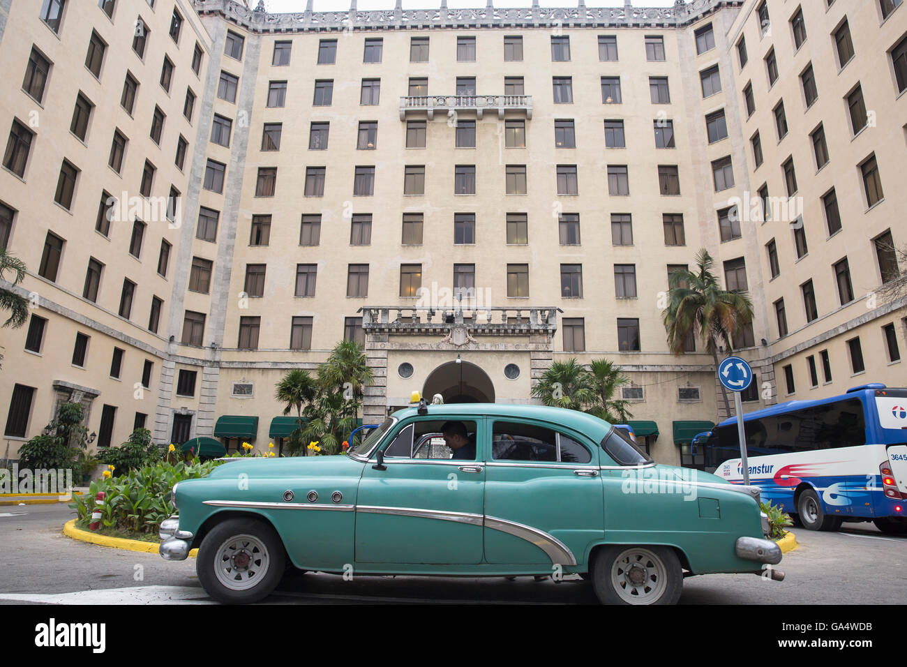 Parte anteriore del famoso Hotel Nacional de Cuba a L'Avana Vecchia, con vintage americano auto usata come una tassa parcheggiato di fronte Foto Stock
