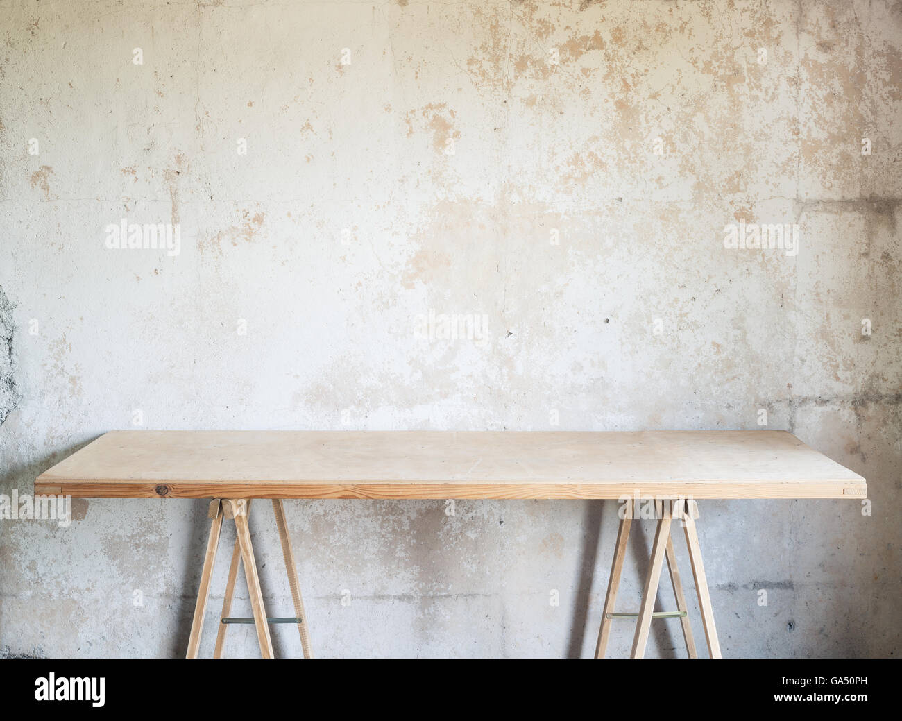 Workshop di legno tabella contro il muro di cemento. Foto Stock