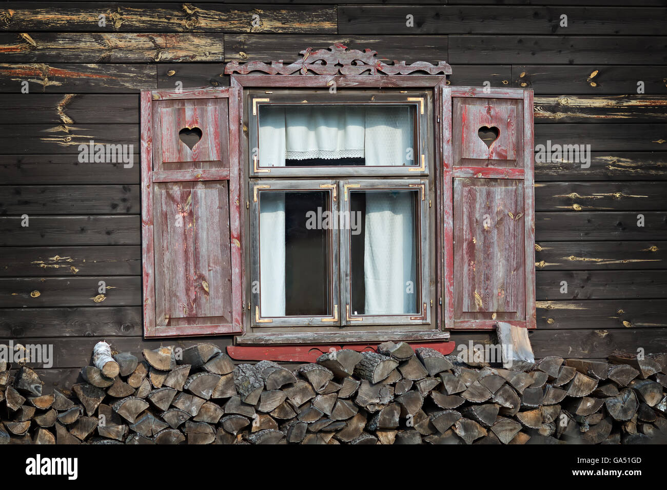 Vecchia casa in legno nel paese con ante aperte Foto Stock