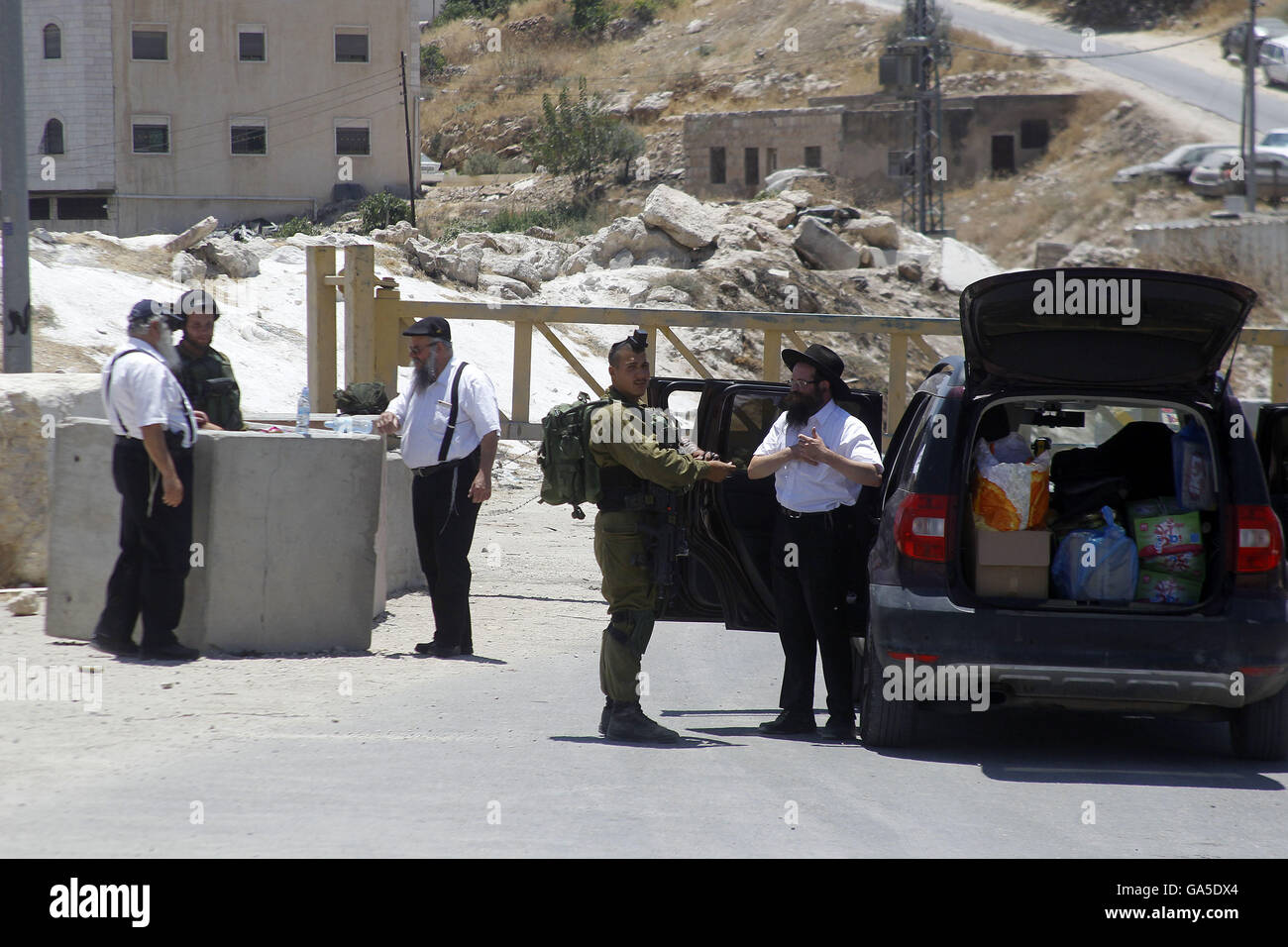 3 luglio 2016 - Hebron, West Bank, Territorio palestinese - soldati israeliani vicino una barriera bloccando la strada ad una entrata sud di Hebron il 3 luglio 2016, come l'esercito mantiene la città sotto lockdown dopo gli scontri e attentati che hanno ucciso due israeliani. Truppe israeliane bloccato Hebron e villaggi circostanti dopo due israeliani sono stati uccisi in attacchi di palestinesi nelle vicinanze.La repressione arriva nel mezzo di una svasatura-fino a nove mesi di violenza micidiale come la fine del musulmano il mese di digiuno del Ramadan telai, e dopo aver portato la chiave diplomatic convocati per passi urgenti da entrambi i lati per ravvivare i moribondi pe Foto Stock