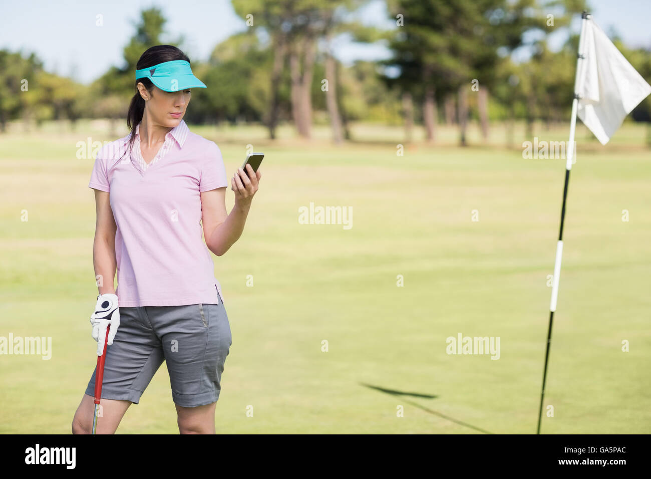 Il Golfer donna usando il telefono Foto Stock