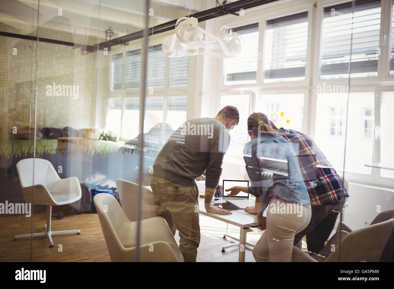 Vista posteriore dei colleghi per discutere in sala riunioni Foto Stock
