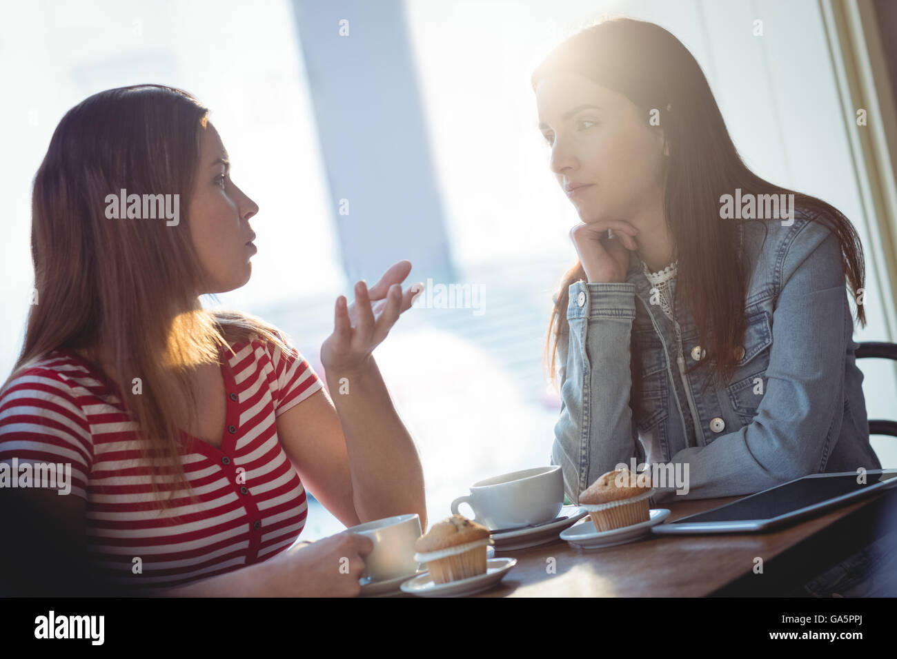 Amici di sesso femminile comunicando al cafe Foto Stock