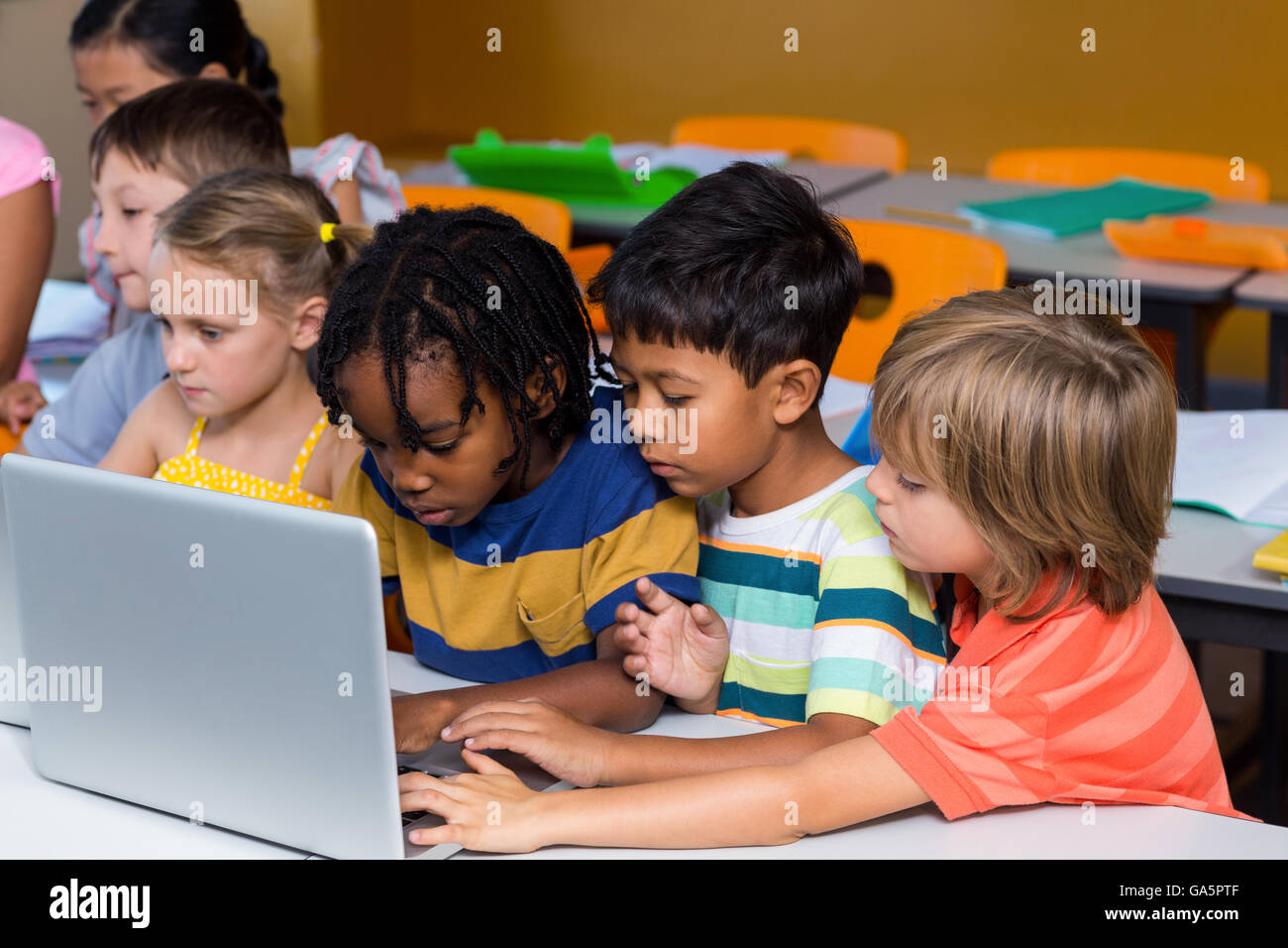 Multi etnico compagni di classe utilizzando laptop Foto Stock