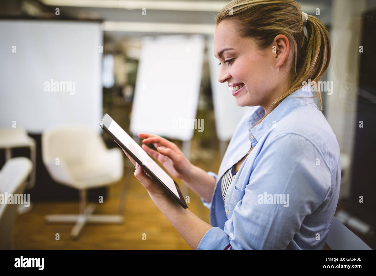 Imprenditrice utilizzando tavoletta digitale nella sala riunioni Foto Stock