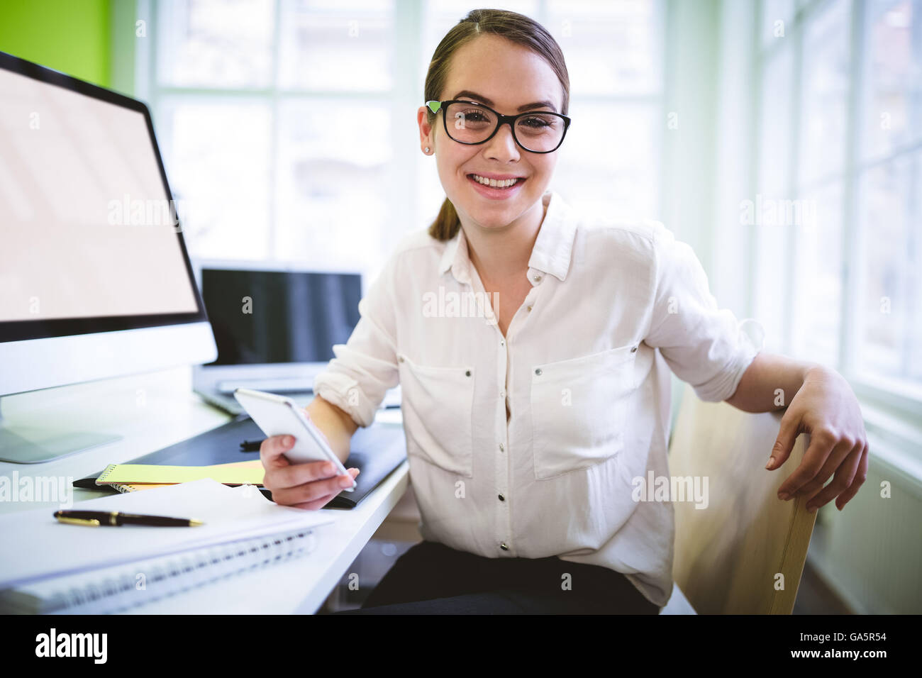 Femmina di graphic designer seduto alla scrivania Foto Stock