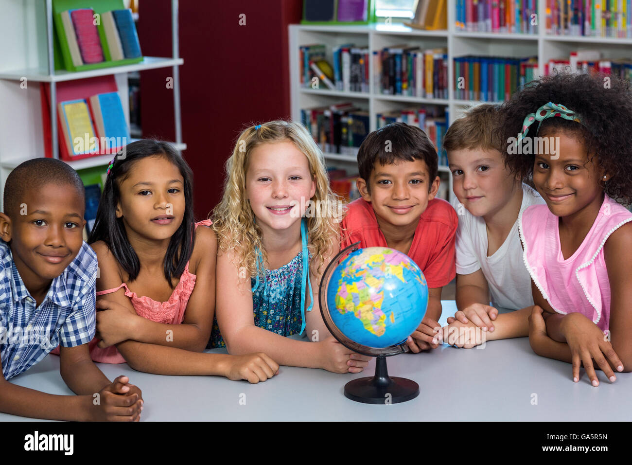 Bambini sorridenti con globo sul tavolo Foto Stock
