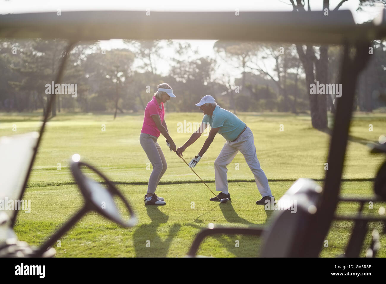 Per tutta la lunghezza della coppia uomo donna di insegnamento per giocare a golf Foto Stock