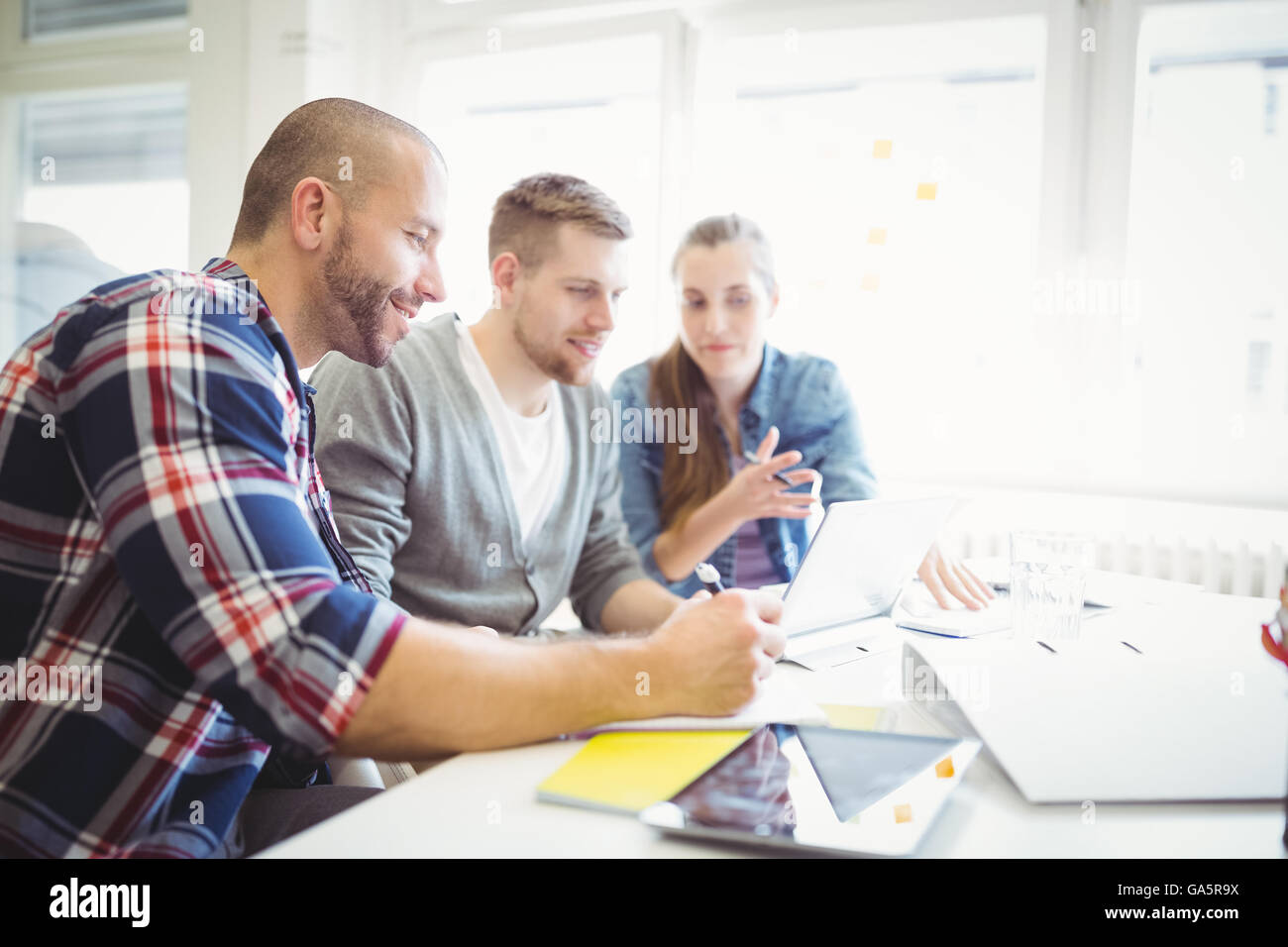 Imprenditore a discutere con i colleghi in ufficio Foto Stock