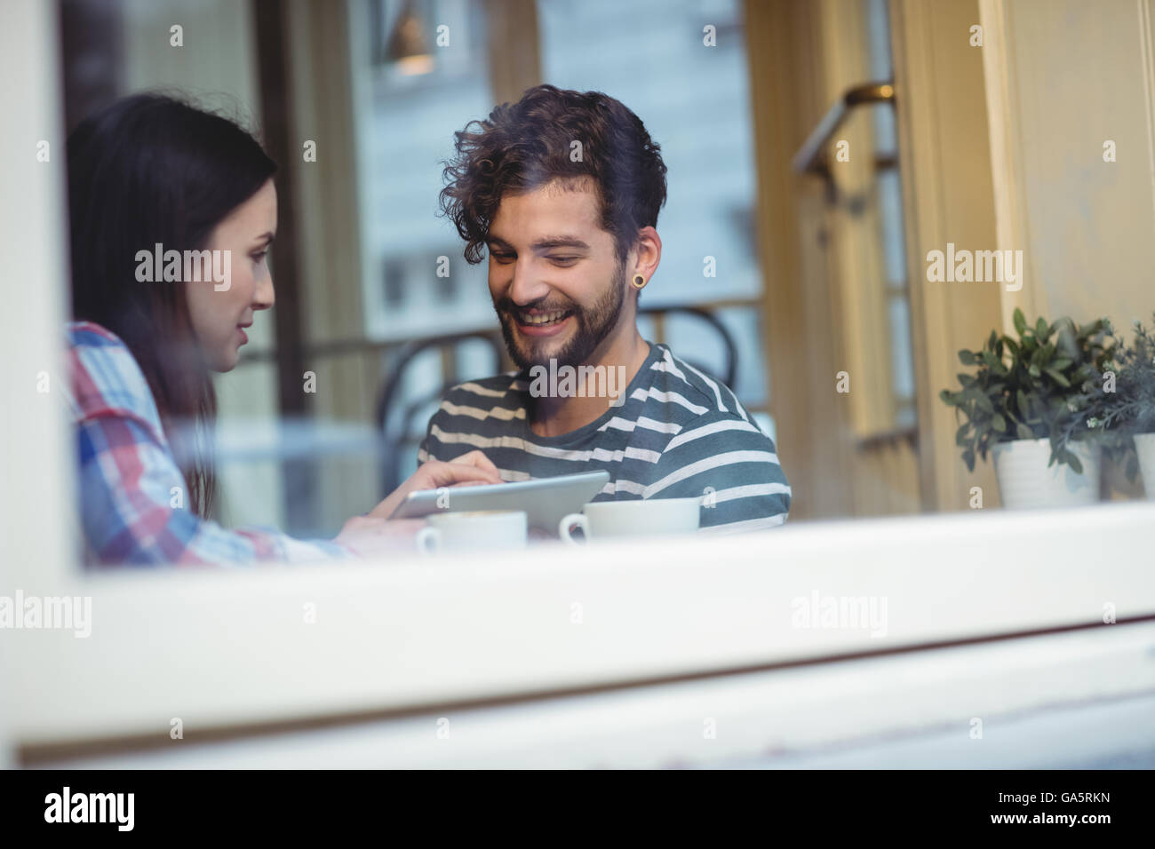 Felice coppia utilizzando tablet pc al cafe Foto Stock